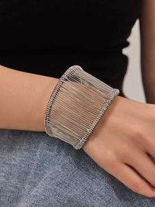Gros plan détaillé d'un large bracelet manchette multicouche en fil d'acier sur un poignet
