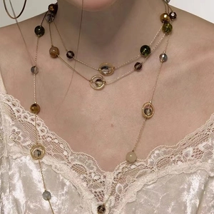 Three-layer vintage beaded tassel necklace featuring metallic circles on model
