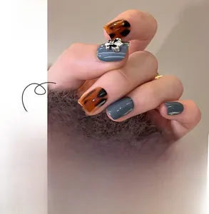 Detail of leopard print and blue-grey press-on nails with silver embossed floral accents