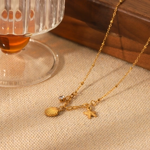 Macro detail of gold starfish and shell pendants with zircon on burlap fabric