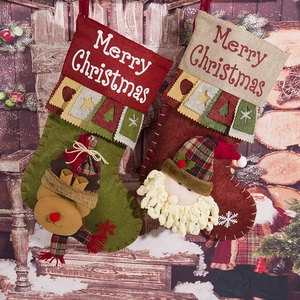 Macro detail of plush Santa and Reindeer Christmas stockings with embroidered greetings