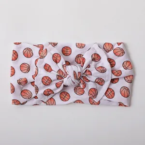 Detailed view of baby headband featuring soft nylon fabric and orange basketball print