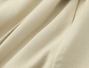 Gros plan sur la texture du tissu en sergé beige pour un ensemble de costume chic