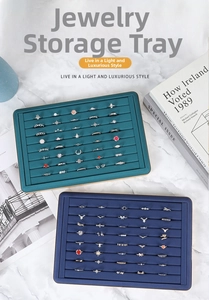Elegant jewelry display trays in teal and navy blue with various gemstone rings