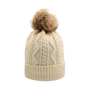 Detailed view of beige cable knit beanie featuring a thick winter texture and brown pompom