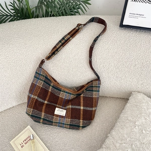 Detail of vintage plaid crossbody bag in thick wool fabric with textured weave