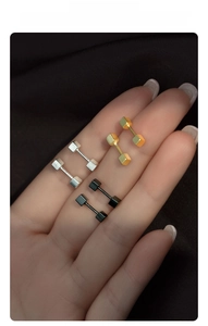Gros plan détaillé des boucles d'oreilles haltères en argent S925 en argent, or et noir