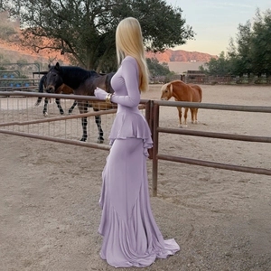 Detailed view of the purple ruffled long sleeves and flowing floor-length hemline
