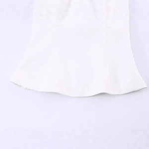 Detailopname van witte mouwloze top met delicate zoom en gebreide textuur