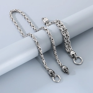 Mens stainless steel skull chain bracelet with hip hop style links on a display stand