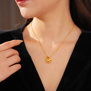 Detailed close-up of a gold-plated necklace with a small horse pendant on a model