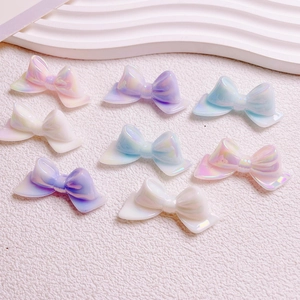 Flat lay of colorful pearlescent resin bow beads for DIY crafts and phone chains