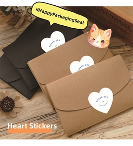 White heart-shaped 'Thank you' stickers with smiley faces on kraft envelopes macro