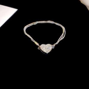 Elegant multi-strand silver necklace featuring a sparkling diamond heart pendant