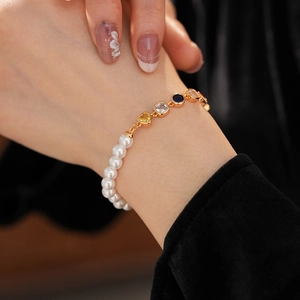 Nahaufnahme eines Vintage Herz Perlenarmbands mit bunten Edelsteinen am Handgelenk