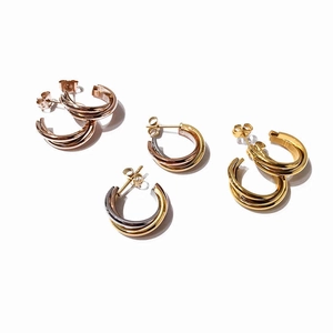 Macro shot of interlocking triple-band earrings in gold rose gold and silver steel