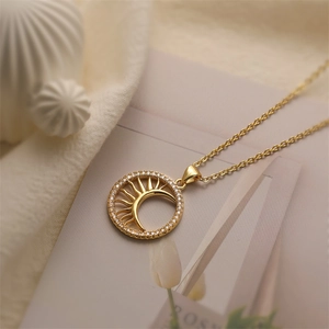 Detailed shot of a gold sun and moon pendant necklace with micro-pave cubic zirconia