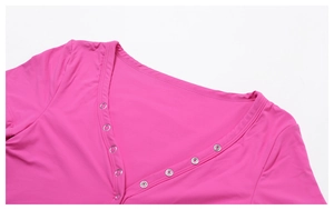 Detail view of the rose pink yoga top with a deep V-neck and metallic ring decoration