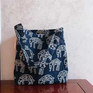 Detail of navy canvas tote bag with white sheep embroidery and metallic clasp closure