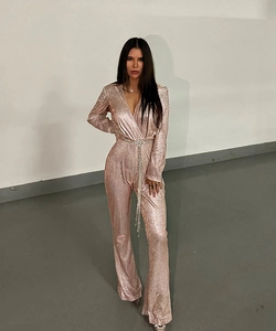 Detail of pink sequin jumpsuit with long sleeves and matching belt for elegant styling