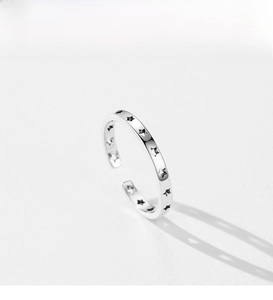 Macro detail of S925 sterling silver open ring featuring engraved black star patterns