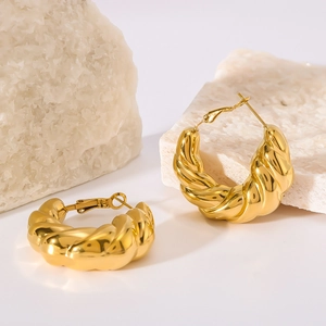 Polished gold croissant texture stainless steel hoop earrings on white stones