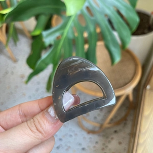 Macro detail of translucent smoky gray triangular hair claw clip with glossy finish