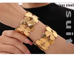 Detail of 18k gold plated stainless steel butterfly cuff bracelets on model