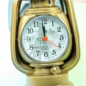 Close-up of retro golden lantern alarm clock featuring Eiffel Tower dial design