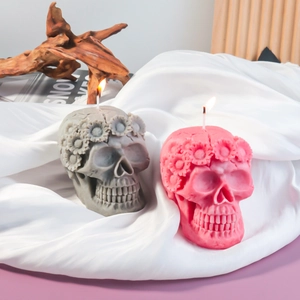 Macro shot of skull candles with sunflower crown texture on white silk fabric
