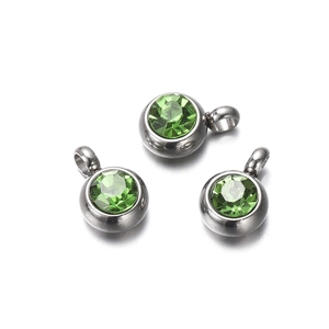 Close-up of three round stainless steel pendants with faceted green zircon stones