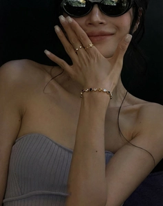 Close-up of gold-plated star ring and colorful zircon bracelet on model's hand