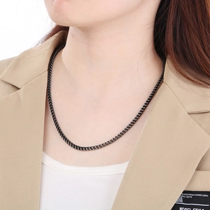 Close-up of black matte dragon bone link chain necklace worn on a classic blazer outfit