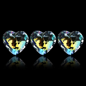 Vue de trois pendentifs en cristal de cœur Aurora avec reflets facettés sur fond noir