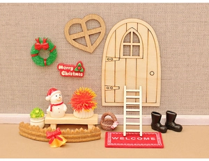 Miniature Christmas dollhouse set with wooden door, snowman, and Merry Christmas sign