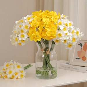Realistic yellow and white silk daffodils in a glass vase for rustic home decor style