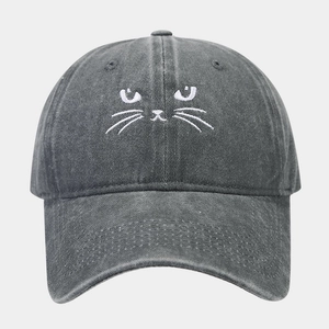 Detail shot of white cat embroidery on dark grey washed cotton baseball cap texture
