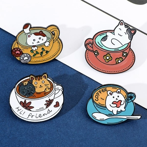 Detail of four colorful cat and bunny enamel coffee cup brooches on a blue background