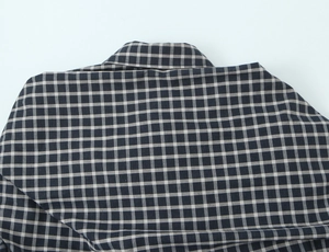 Close-up of black and white plaid shirt fabric detail showing fine textile texture