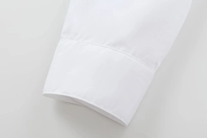 Détail des coutures et des poignets d'une chemise ample en coton blanc pour femmes