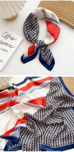 Macro detail of satin silk scarf with red blue geometric patterns on wooden tray