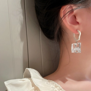 Irregular white circle earrings with transparent cube pendants on model for elegant style