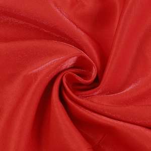 Vue macro du tissu en satin rouge de haute qualité montrant un fini soyeux brillant