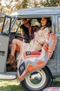 Close-up of Bohemian knit blanket with colorful tassels in a cozy outdoor camping setting