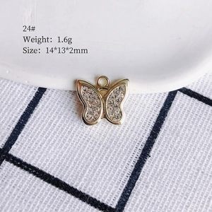 Detailed view of a gold-plated butterfly charm with white crystals measuring 14x13x2mm