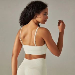 Detail of seamless ribbed knit fabric on cream yoga bra with adjustable thin straps
