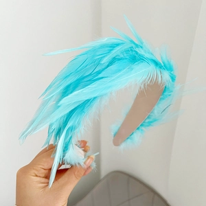 Detailed view of handmade headband featuring soft blue feathers and beige fabric base