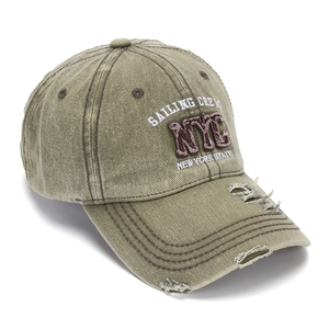 Detailed view of the distressed olive green NYC embroidered washed denim baseball cap