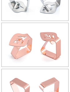 Detailed close-up of leaf-shaped stainless steel tablecloth clips in silver and rose gold