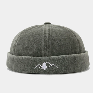 Detailed view of mountain and tree embroidery on a vintage grey washed cotton docker hat